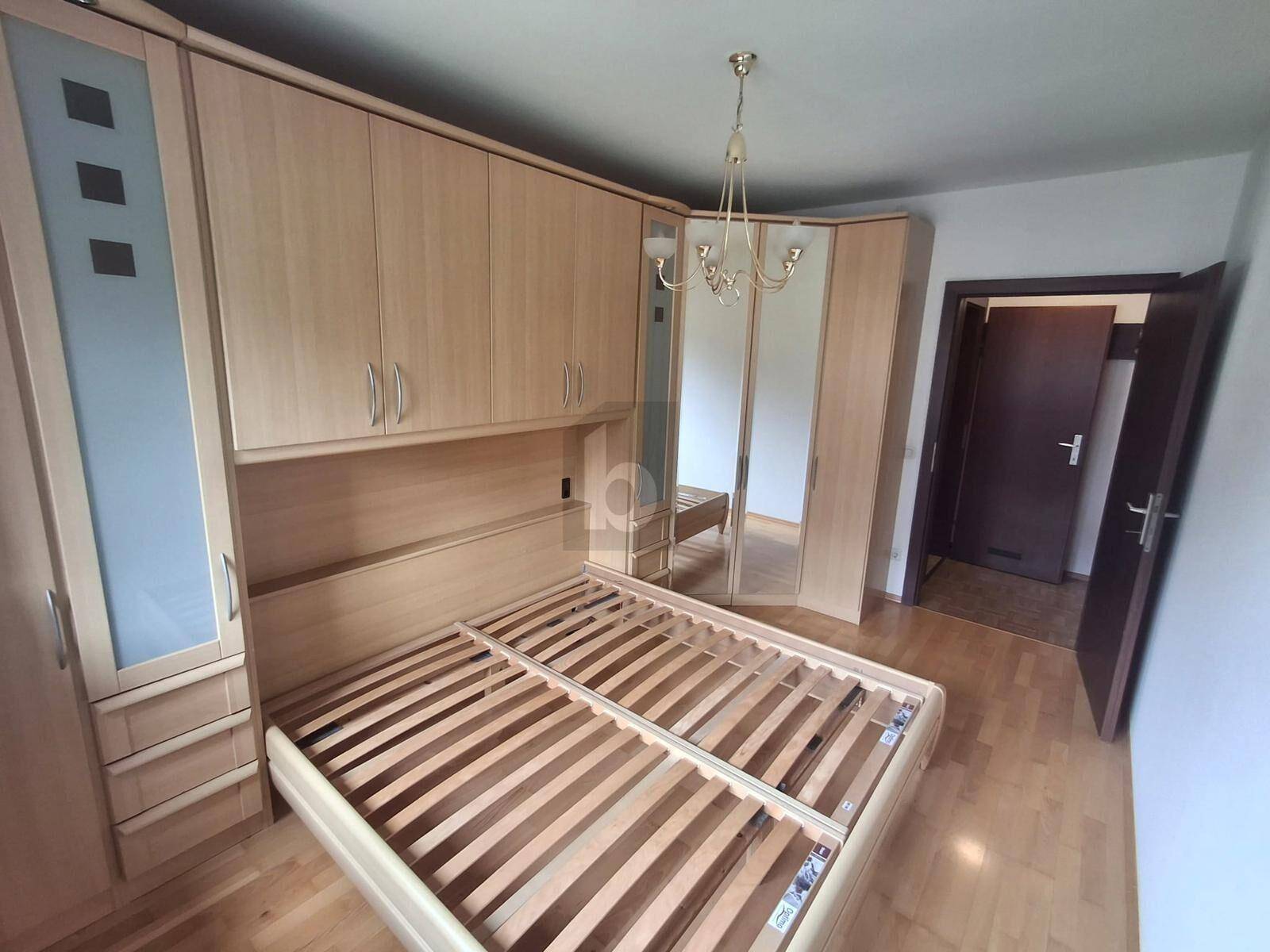 Schlafzimmer mit großem Einbauschrank, integriertem Bett und Spiegeln.