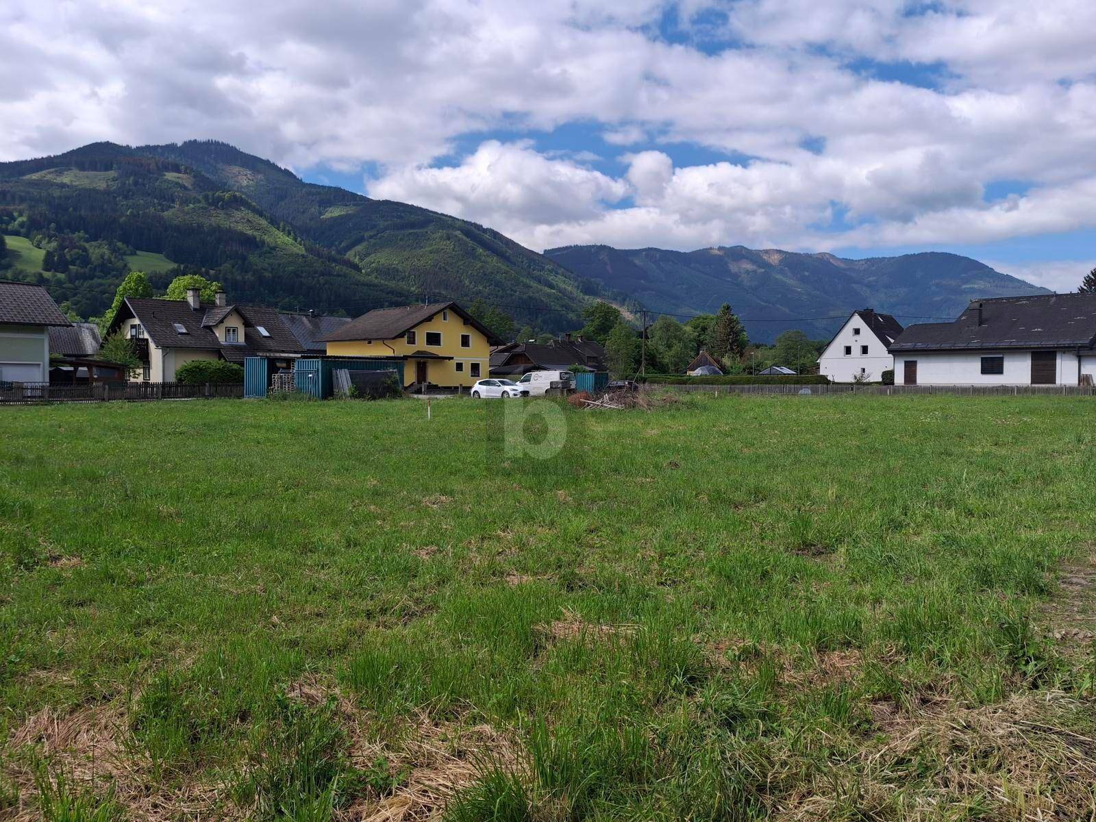 Offene Grünfläche mit Blick auf die Nachbarschaft und die umliegende Berglandschaft.