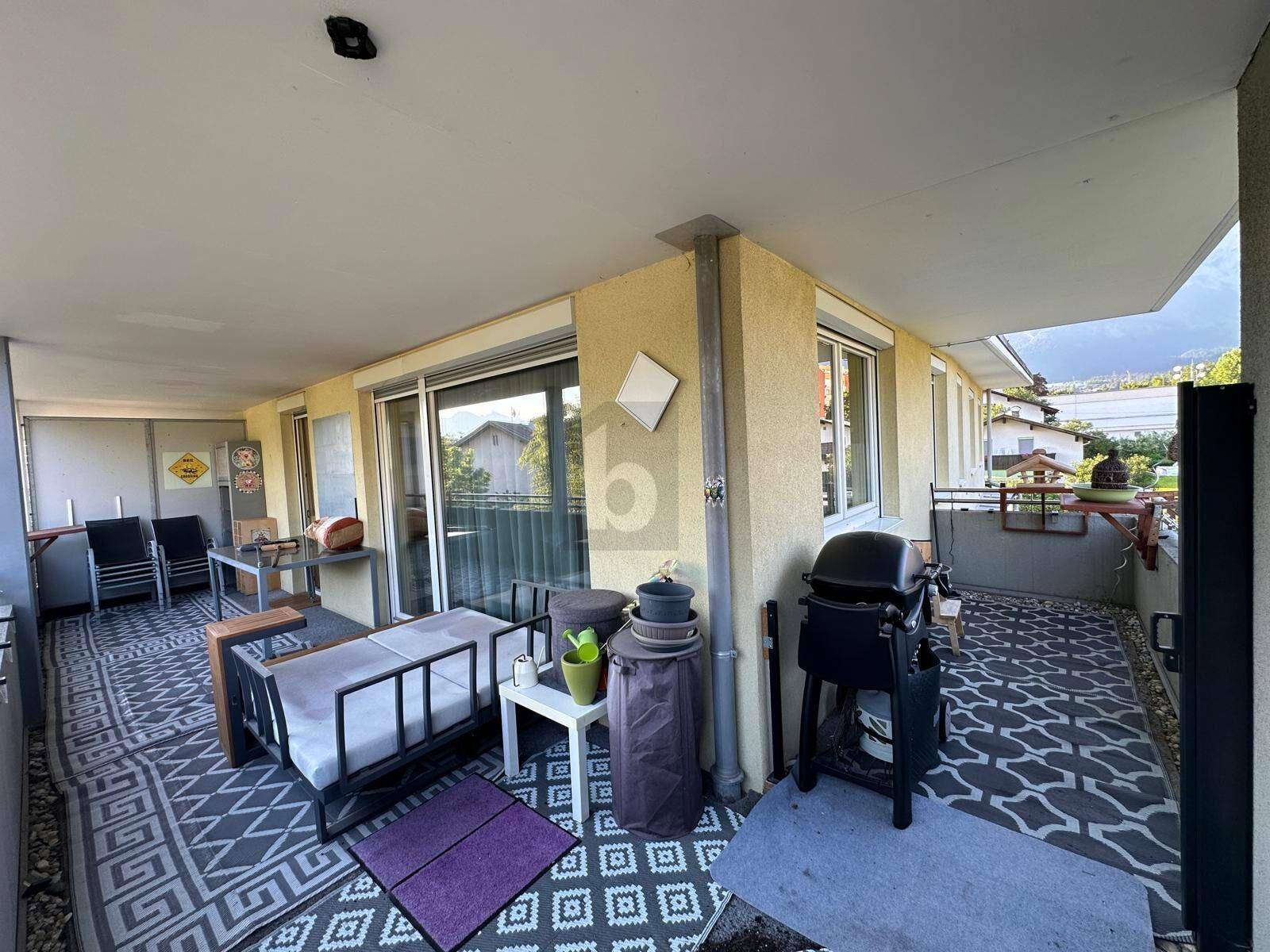Geräumiger Balkon mit Sitzgelegenheiten, Grill und weitem Blick auf die umliegenden Berge.