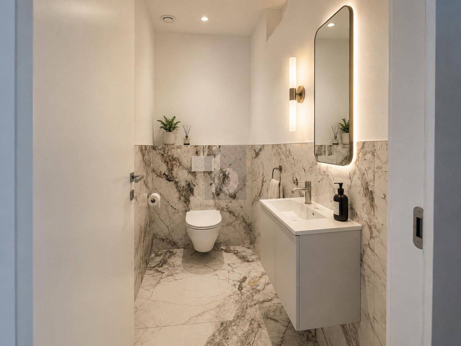 Stilvolles Gäste-WC mit Marmorfliesen, modernem Waschtisch und wandhängendem WC.