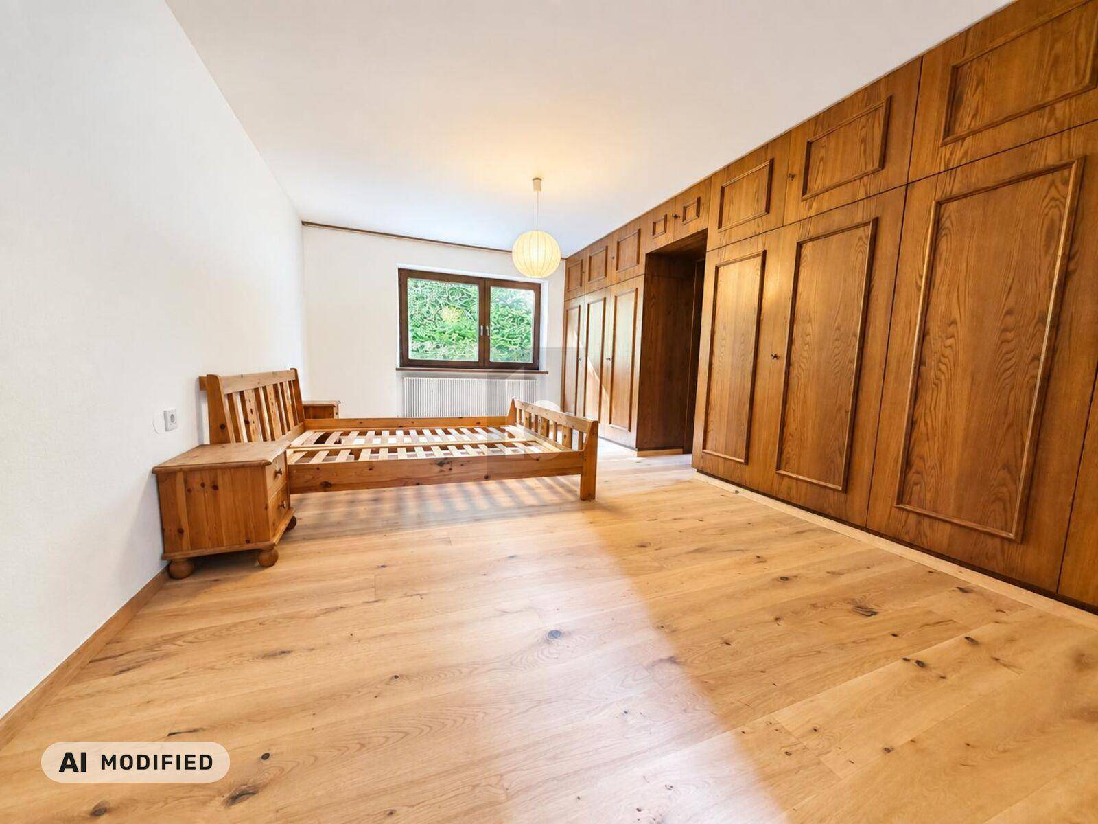 Schlafzimmer mit Holzbett, Einbauschränken aus Holz und hellem Holzboden.
