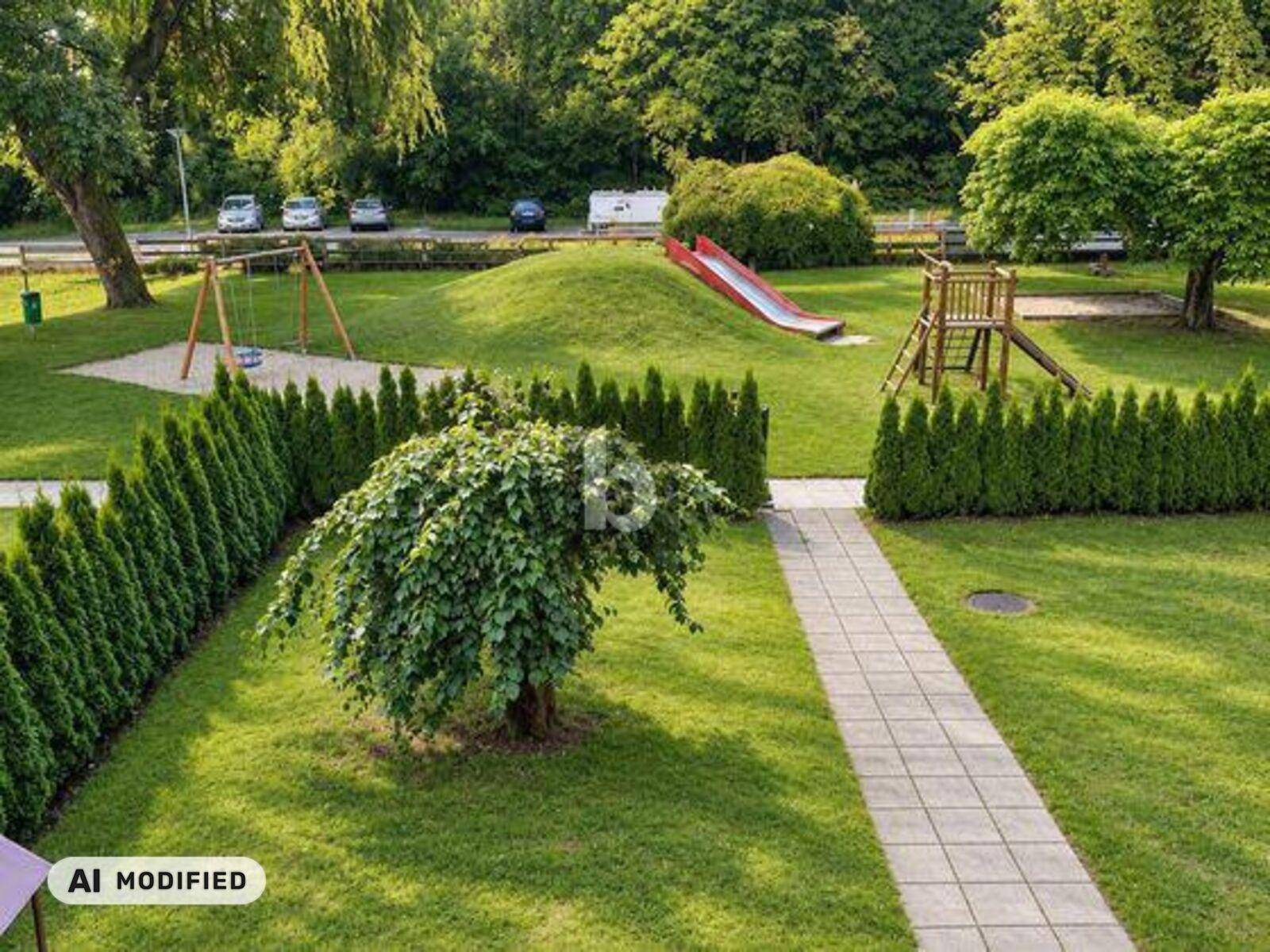 Grüner Gartenbereich mit Kinderspielplatz, Rutsche und Schaukeln, umgeben von Hecken.