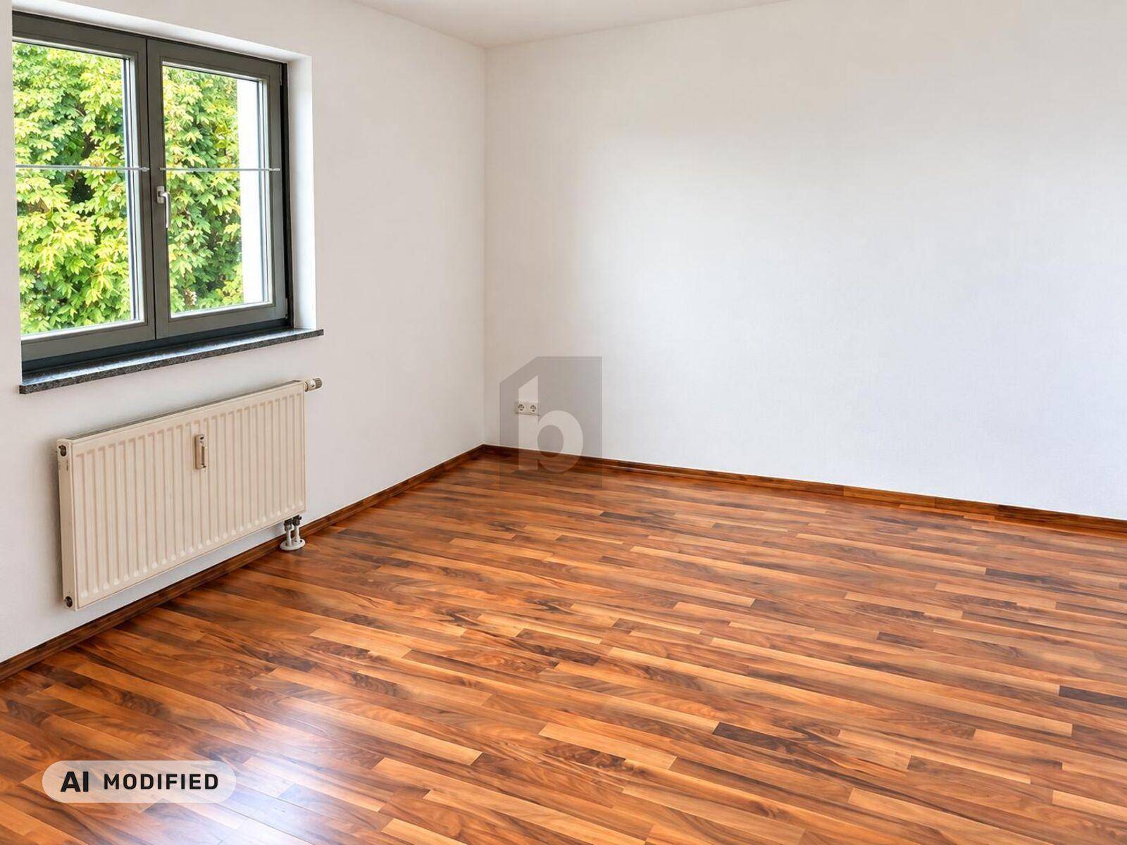 Helles Zimmer mit Laminatboden, weißen Wänden und einem Fenster mit Blick ins Grüne.