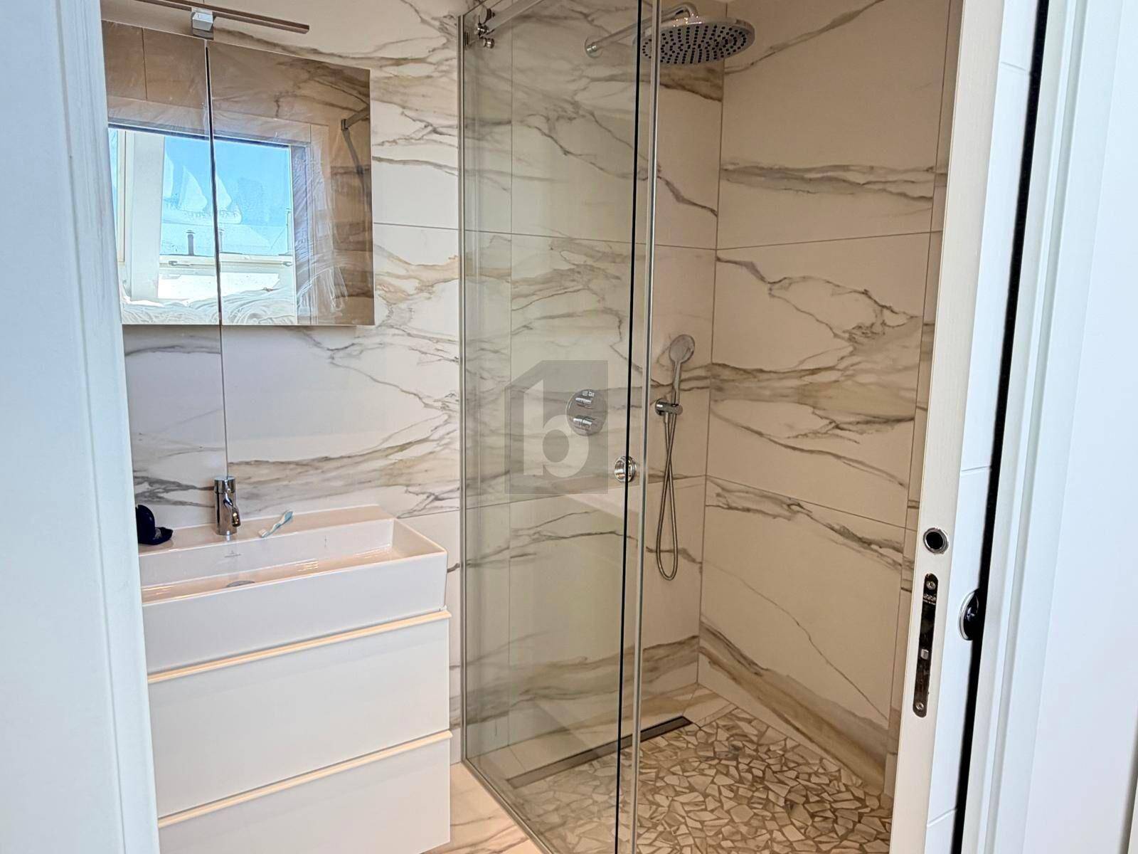 Modernes Badezimmer mit begehbarer Dusche, Marmorfliesen und elegantem Einzelwaschbecken.