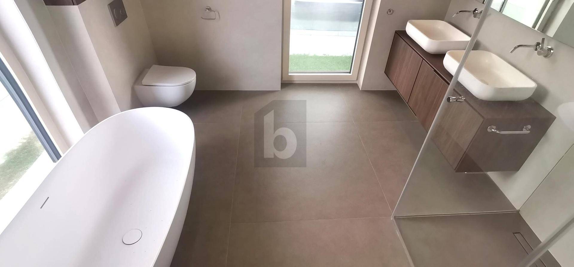 Modernes Badezimmer mit freistehender Badewanne, Doppelwaschbecken und begehbarer Dusche.