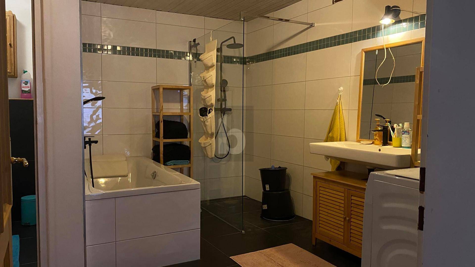 Modernes Badezimmer mit Badewanne, begehbarer Dusche und Waschbecken.