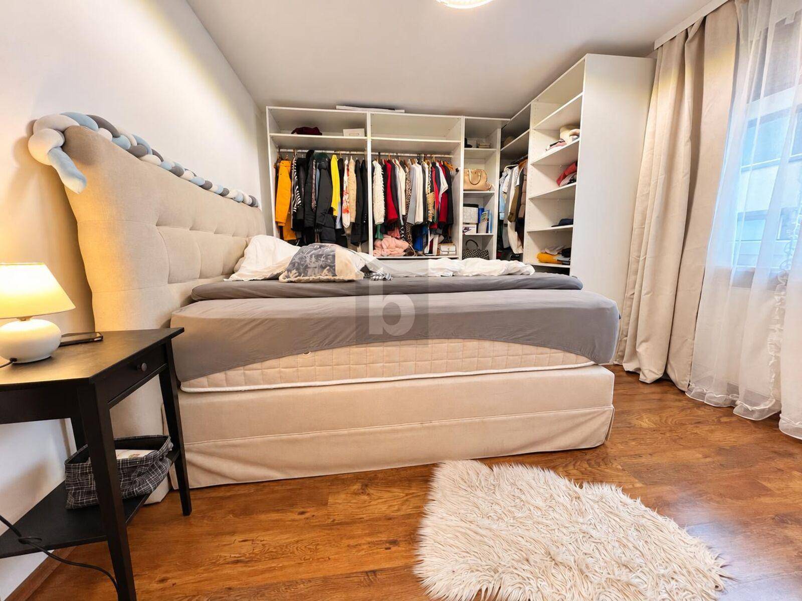 Gemütliches Schlafzimmer mit großem Bett, integriertem Kleiderschrank und Holzboden.