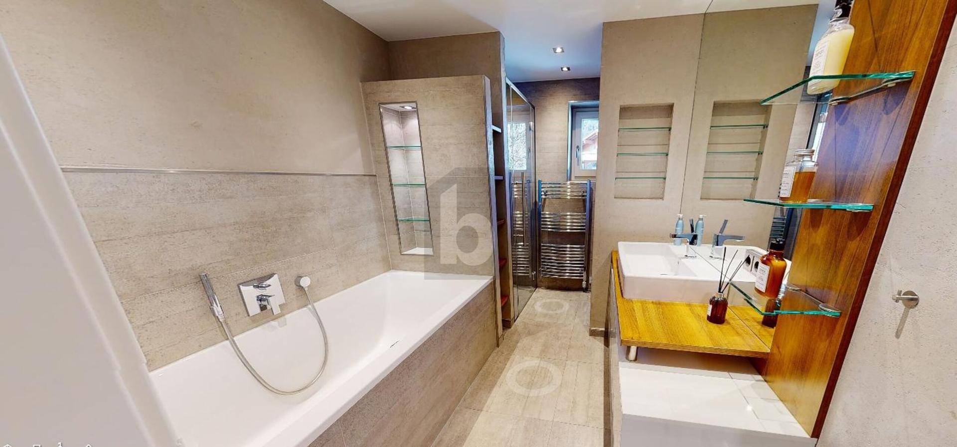 Modernes Badezimmer mit Badewanne, Doppelwaschbecken und beheiztem Handtuchhalter.