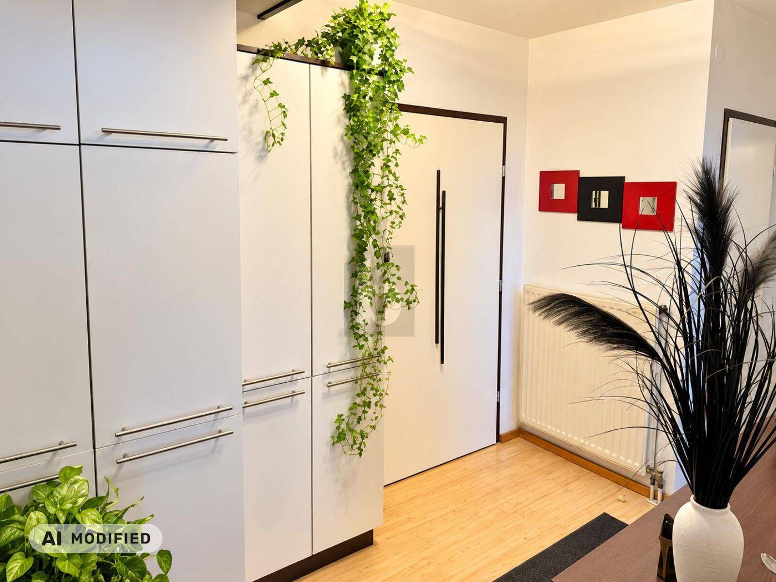 Heller Eingangsbereich mit modernen weißen Einbauschränken und Holzboden.