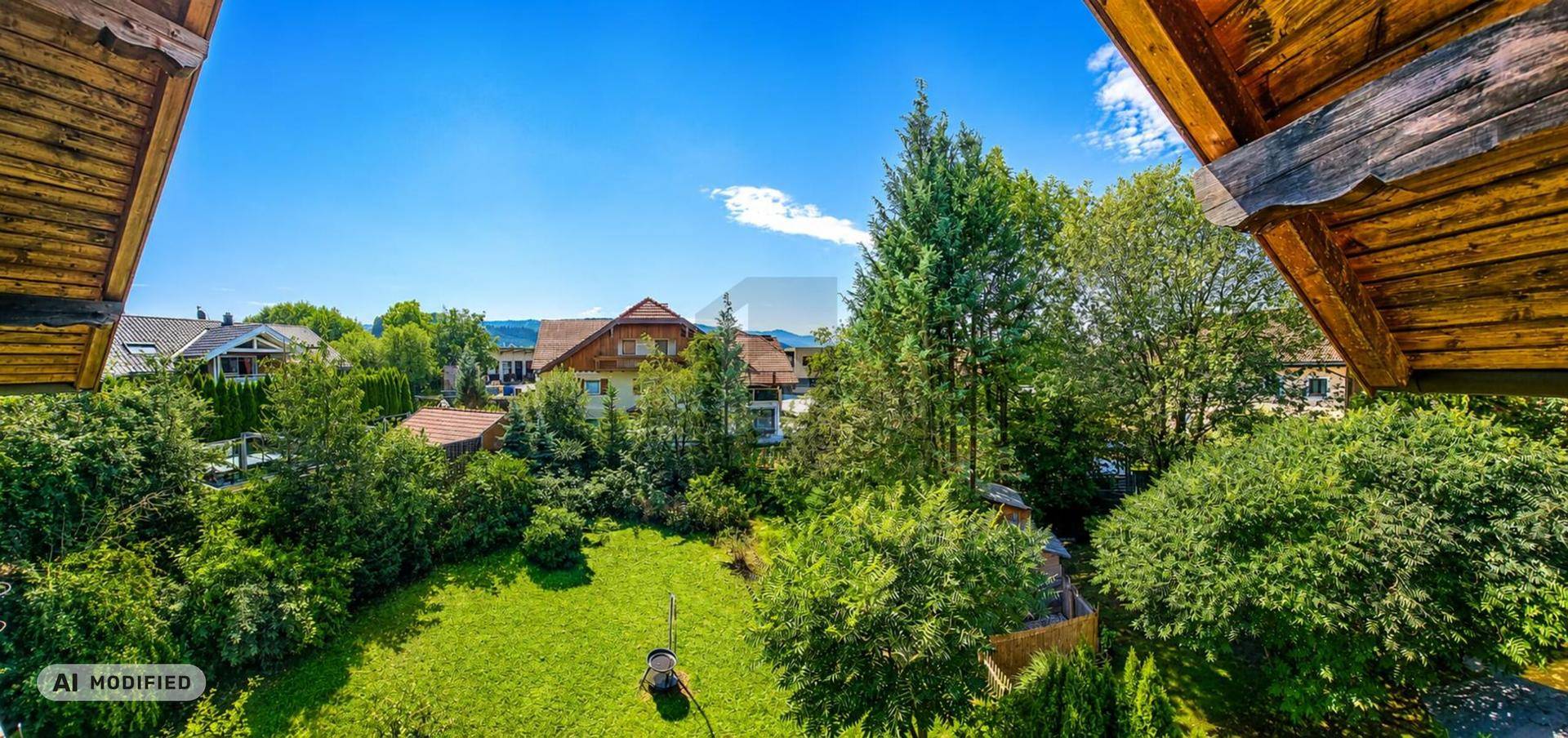 Panoramablick über eine grüne Wohngegend mit vielen Bäumen und Häusern unter blauem Himmel.