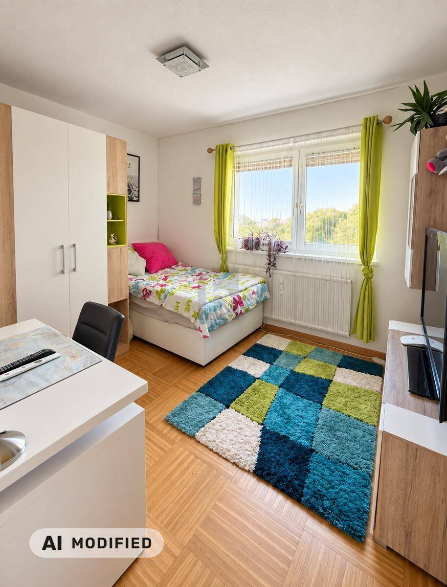 Kinder- oder Gästezimmer mit Einzelbett, Schreibtisch und farbenfrohem Teppich.