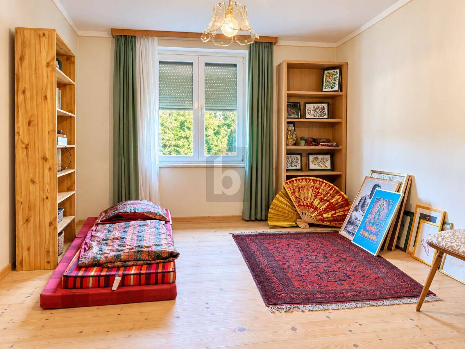 Geräumiges Schlafzimmer mit Holzboden, Fenster und vielseitiger Nutzungsmöglichkeit.