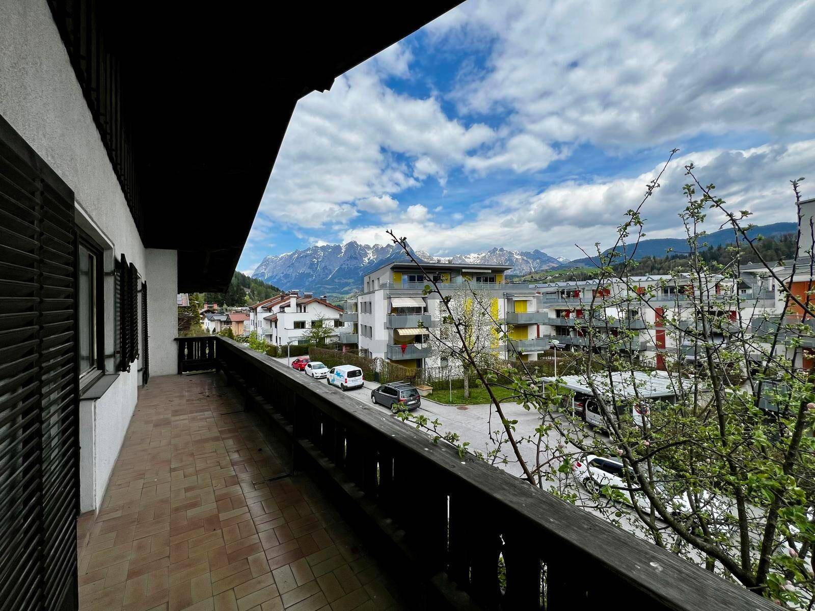 Geräumiger Balkon mit Fliesenboden und weitem Blick auf die Berge und die Umgebung.
