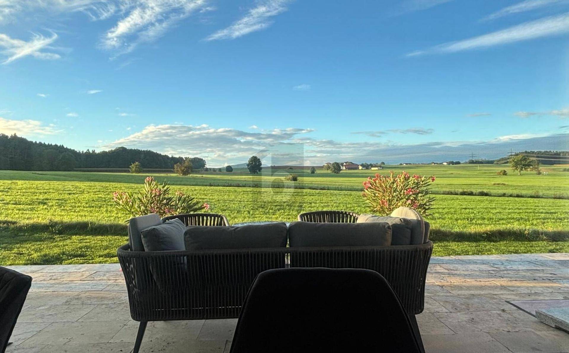 Entspannter Außenbereich mit bequemen Sitzgelegenheiten und weitem Blick über die grüne Landschaft.