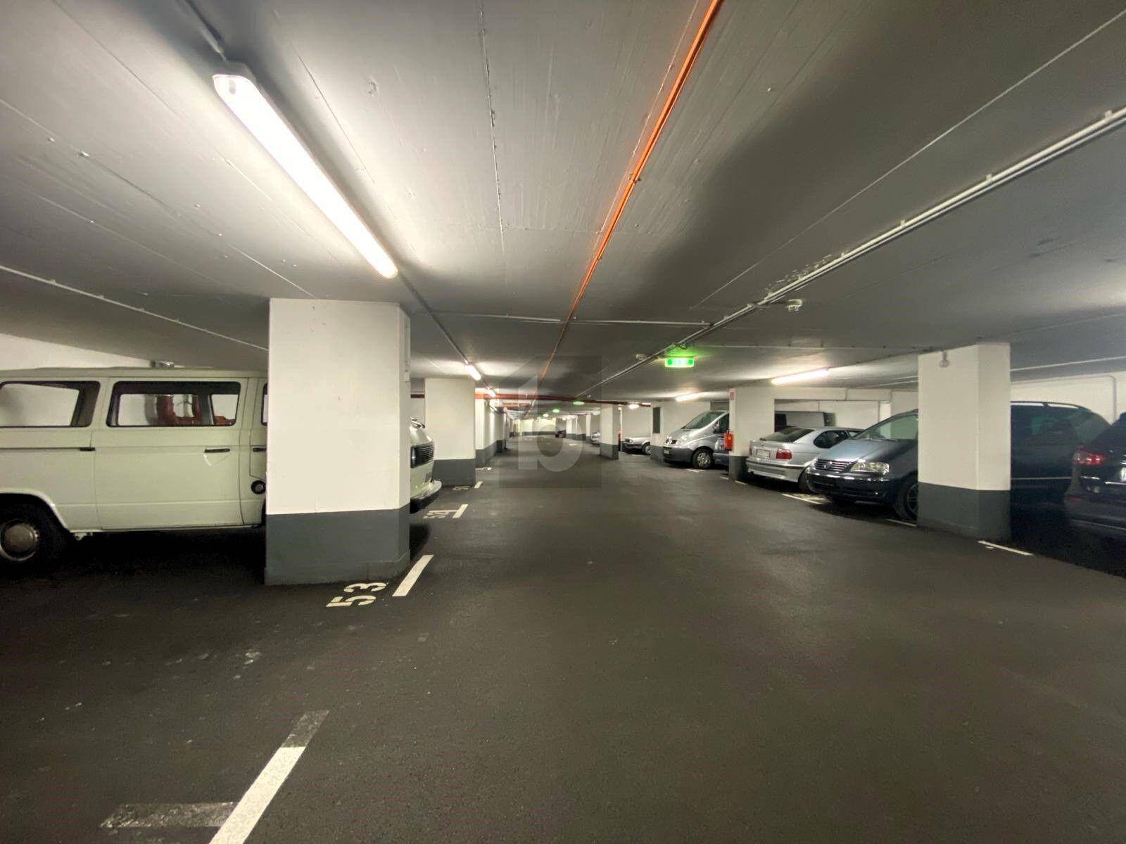 Geräumige und helle Tiefgarage mit mehreren Stellplätzen und guter Beleuchtung.
