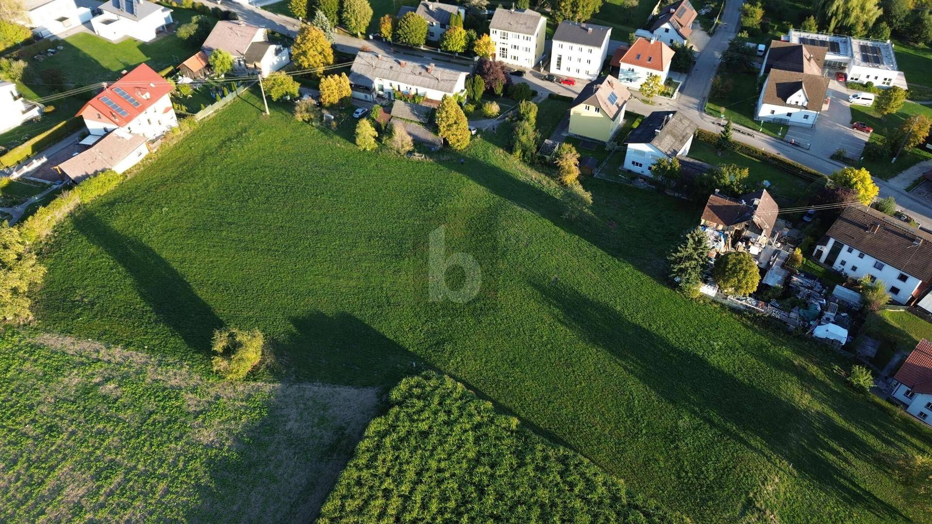 Luftaufnahme eines großen grünen Grundstücks umgeben von Wohngebäuden und Straßen.