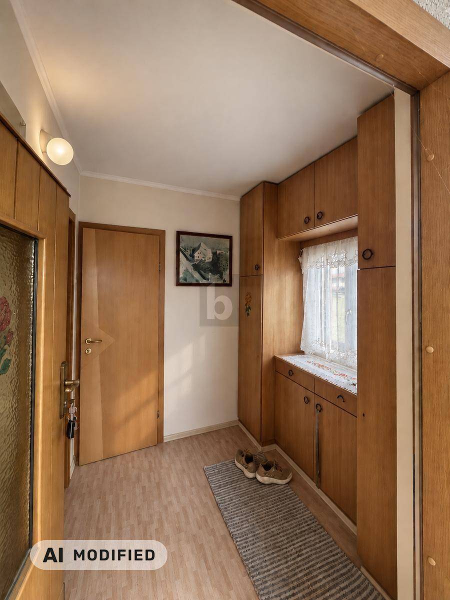 Eingangsbereich mit Holzvertäfelung, Einbauschränken und Laminatboden.