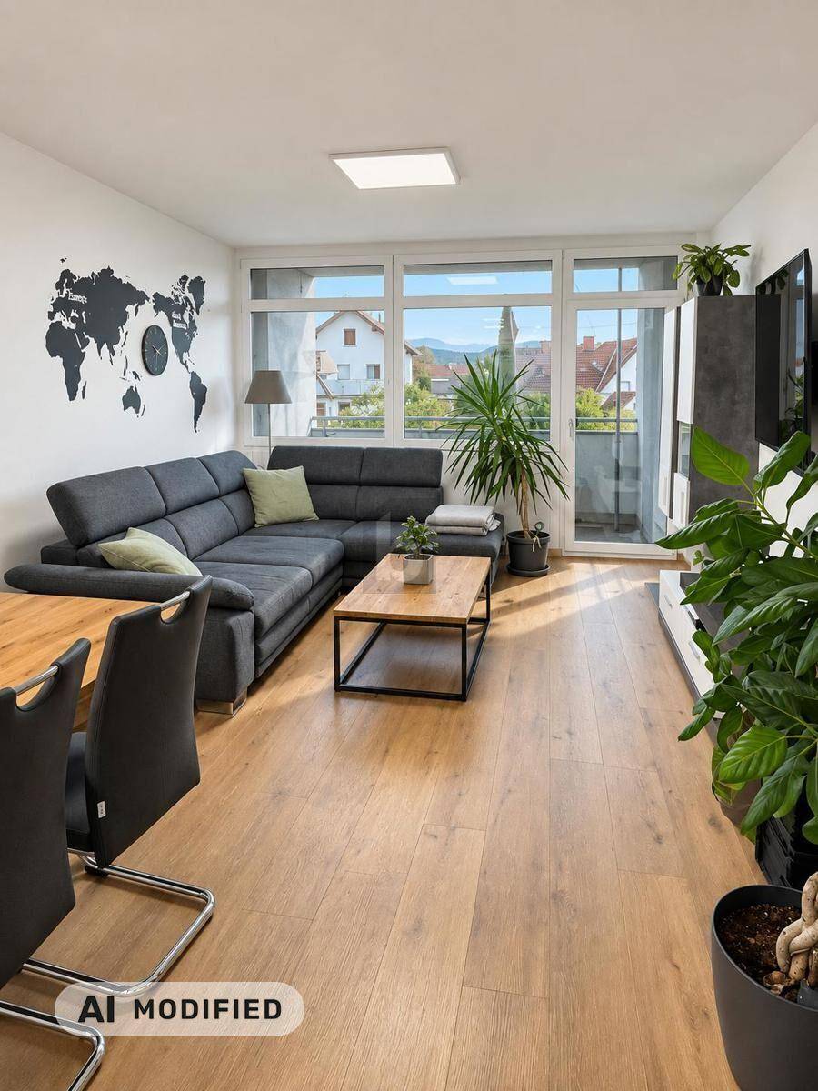 Heller Wohn-Essbereich mit großem Sofa, Holzboden und Zugang zu einem Balkon mit Aussicht.