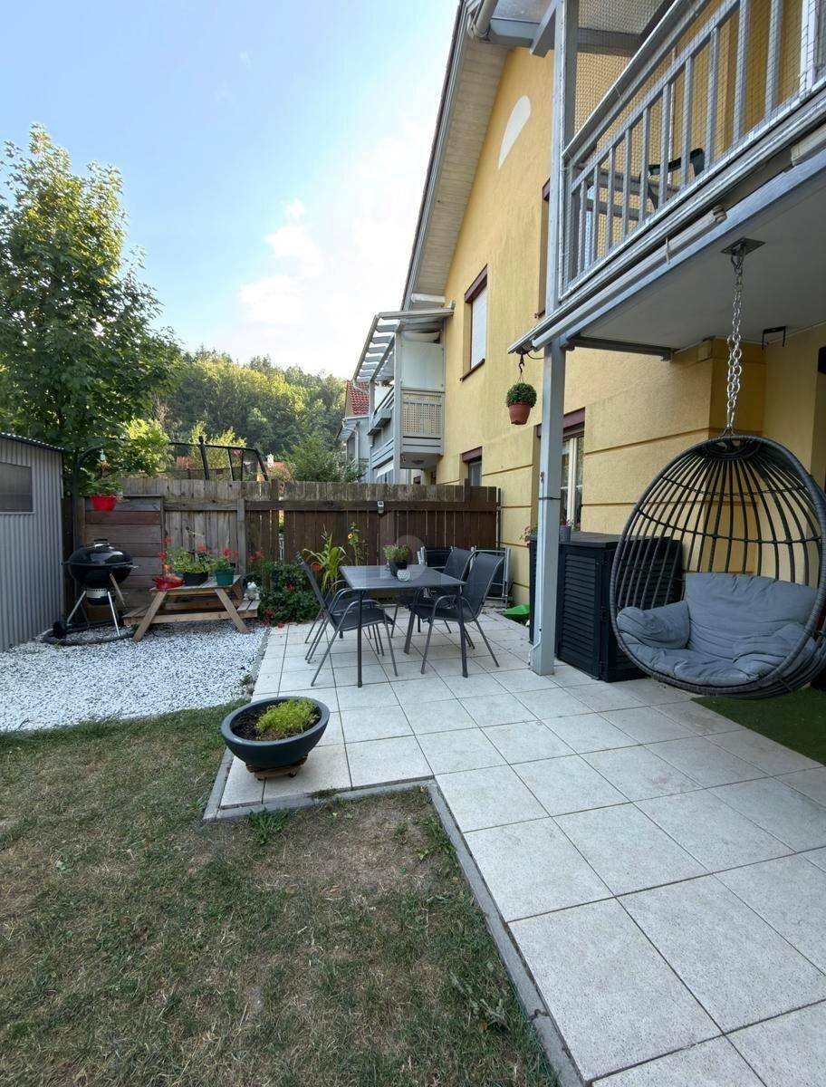 Gemütliche Terrasse mit Essbereich, Hängesessel und Zugang zum Garten.