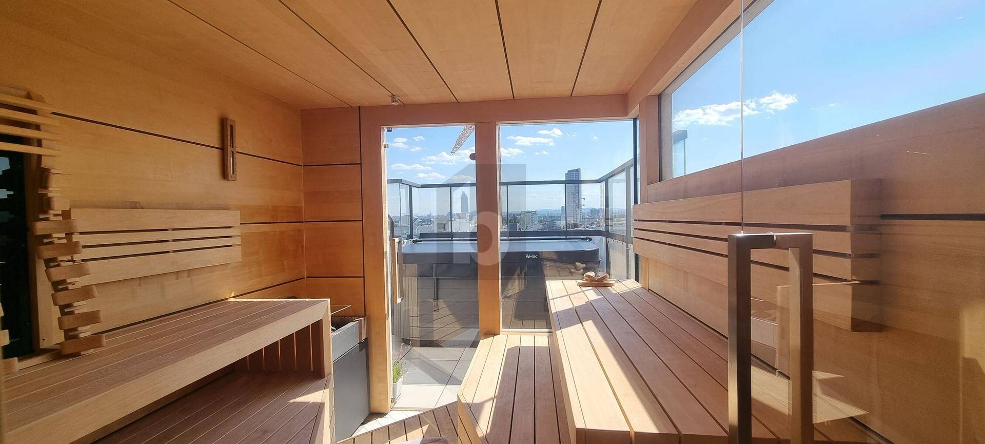 Moderne Holzsauna mit großen Glasfronten und Blick auf den Außenbereich mit Whirlpool.