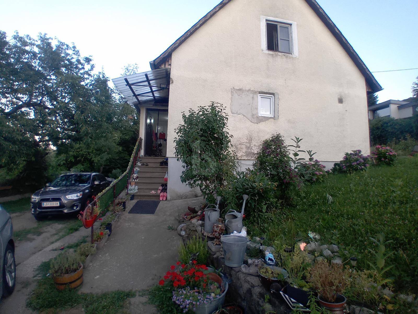 Rückansicht des Hauses mit Eingangsbereich, überdachtem Zugang und gepflegtem Garten.