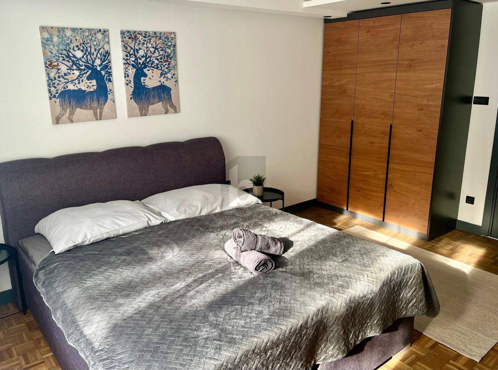 Gemütliches Schlafzimmer mit Doppelbett, Holzboden und modernem Einbauschrank, sonnendurchflutet.