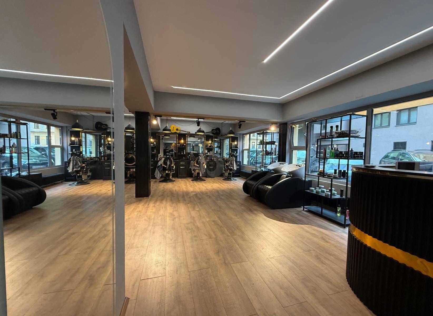 Weitläufiger Friseursalon mit moderner Einrichtung, vielen Bedienplätzen und großen Fenstern.