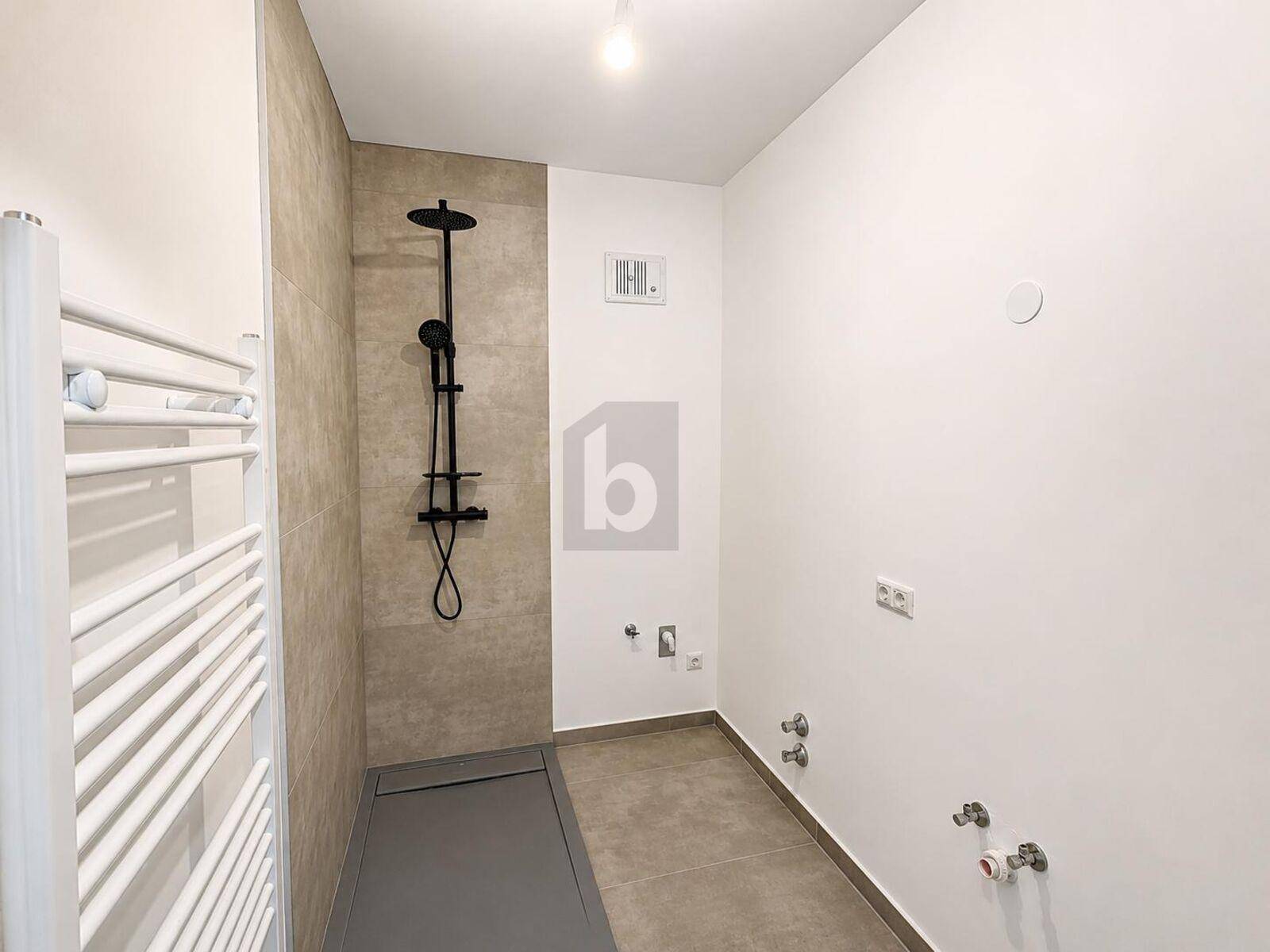Modernes Badezimmer mit ebenerdiger Dusche, Fliesen und Heizkörper für Handtücher.