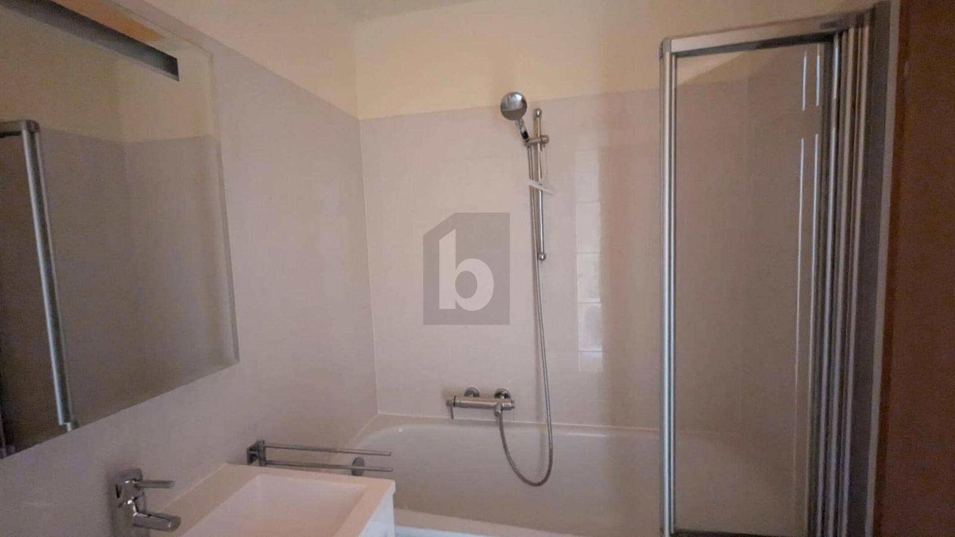 Funktionales Badezimmer mit Badewanne, Duschbereich, Waschbecken und Spiegelschrank.