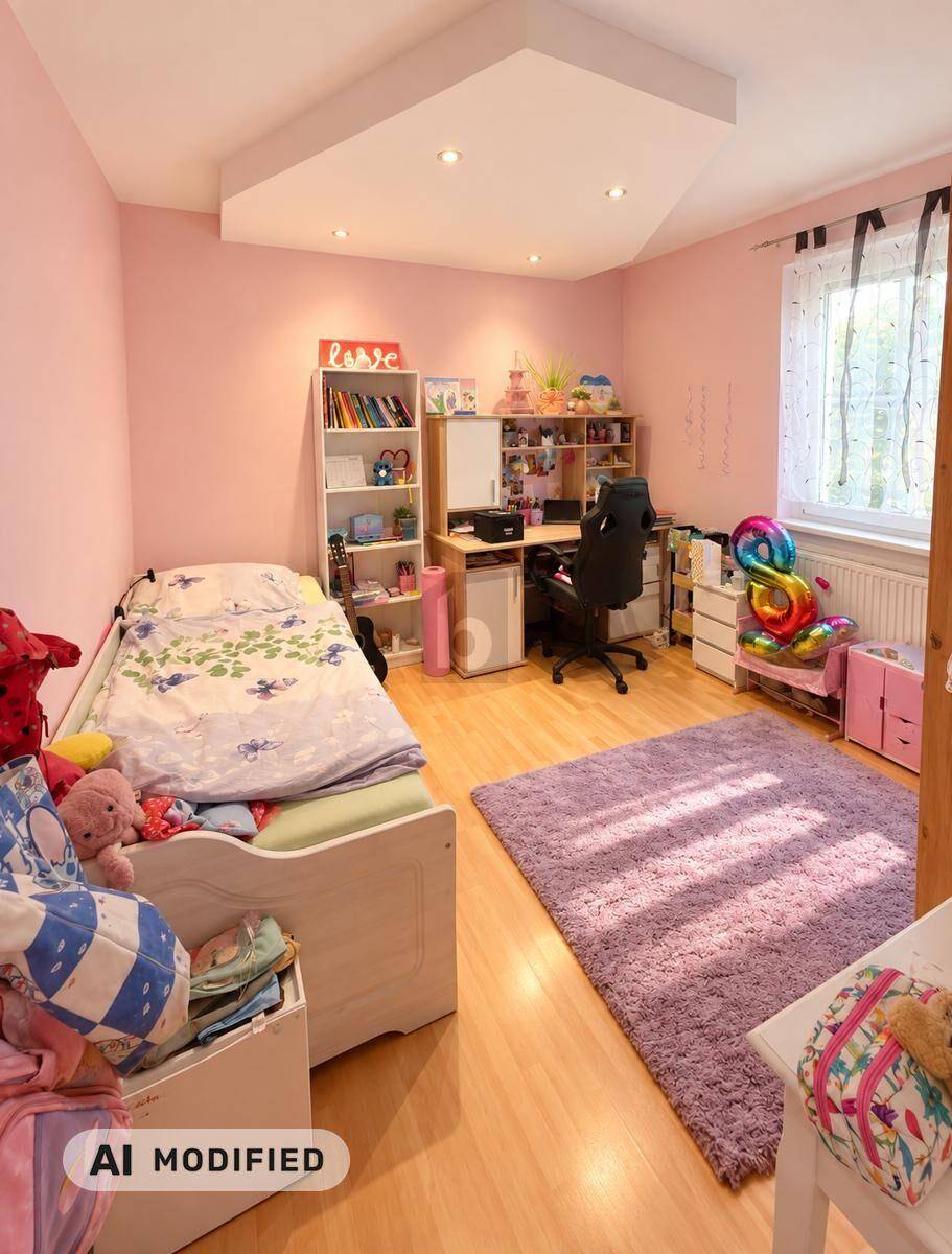 Kinderzimmer mit rosa Wänden, Bett, Schreibtisch und Spielzeug, gut beleuchtet.