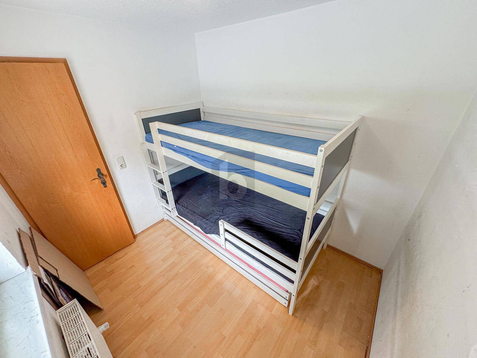 Kleines Schlafzimmer mit Etagenbett und Laminatboden, ideal für Kinder oder Gäste.