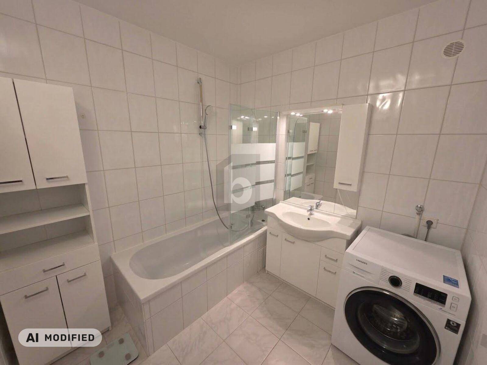 Funktionales Badezimmer mit Badewanne, Duschfunktion, weißen Fliesen und integrierter Waschmaschine.