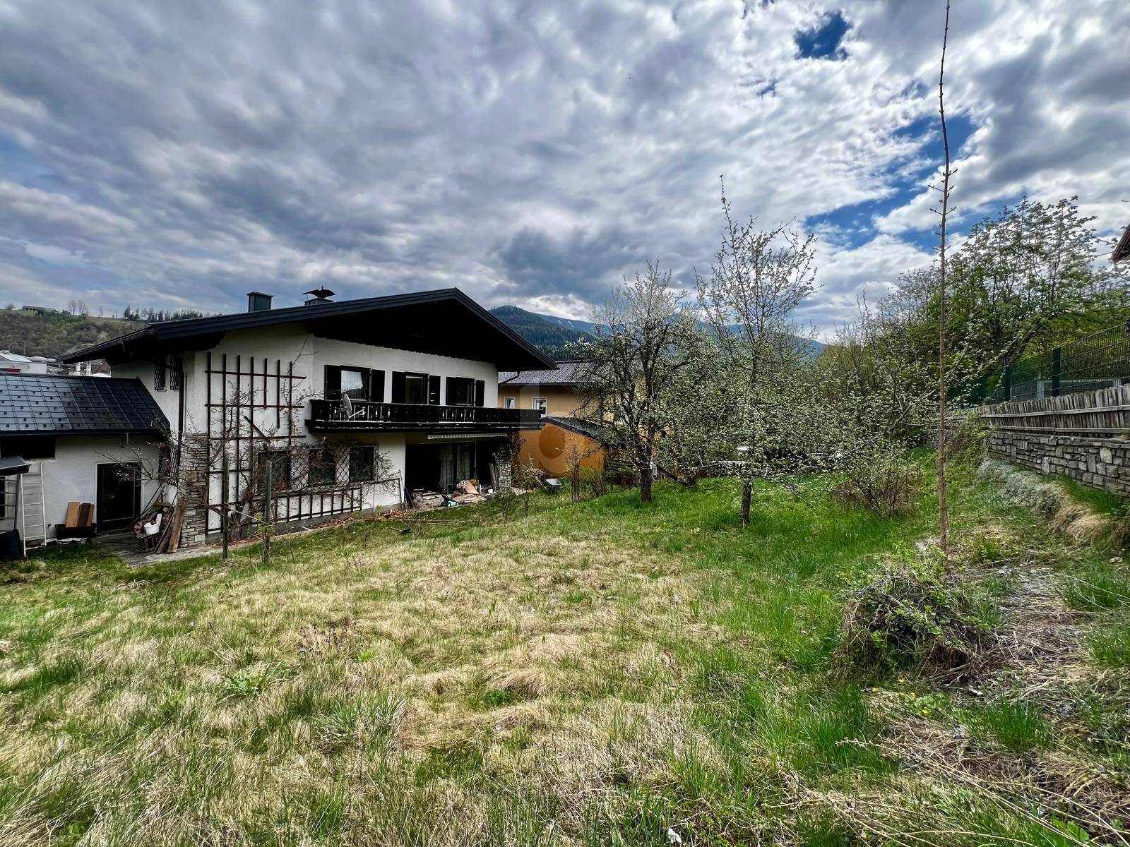 Großer Gartenbereich hinter dem Haus mit Blick auf die umliegende Berglandschaft.