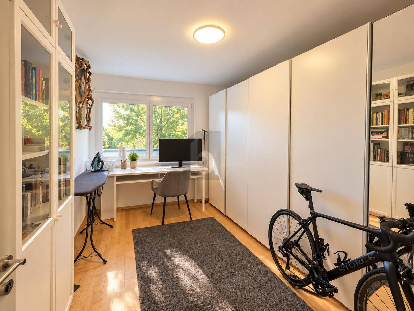 Helles Arbeitszimmer mit großem Fenster, Einbauschränken und Blick ins Grüne, auch als Gästezimmer nutzbar.