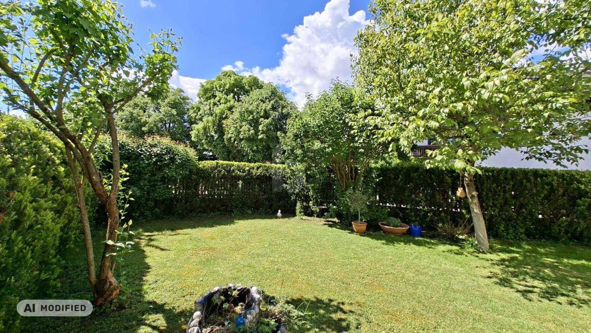 Gepflegter Garten mit Rasenfläche, Bäumen und Hecke, ideal zum Entspannen im Freien.