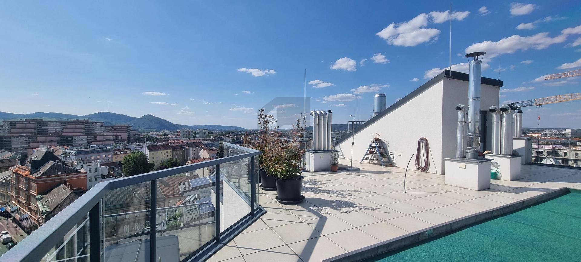 Große Dachterrasse mit Panoramablick über die Stadt und die umliegenden Berge.