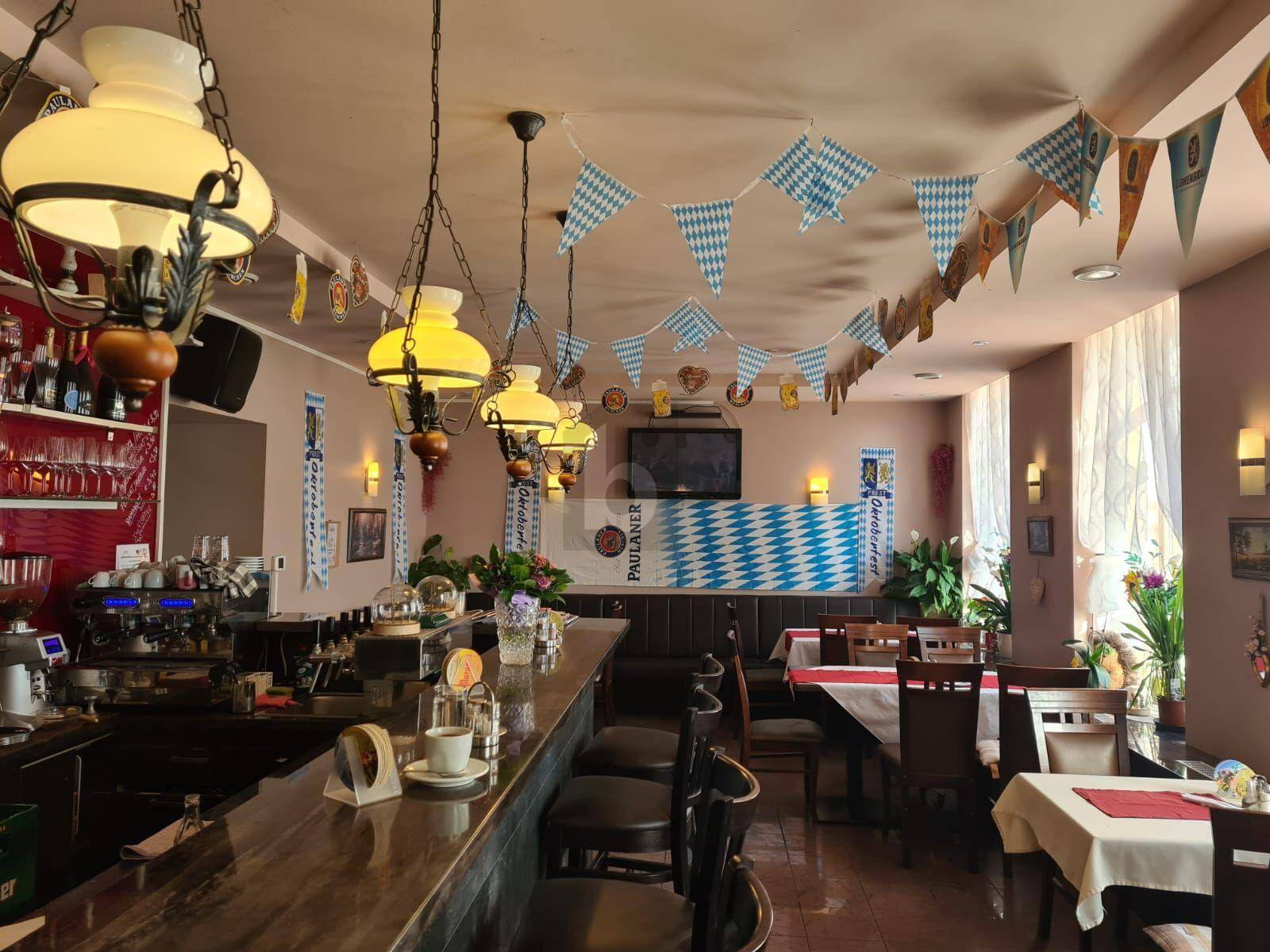 Traditionelles Restaurant mit langer Holztheke, bayerischer Dekoration und gemütlicher Beleuchtung.