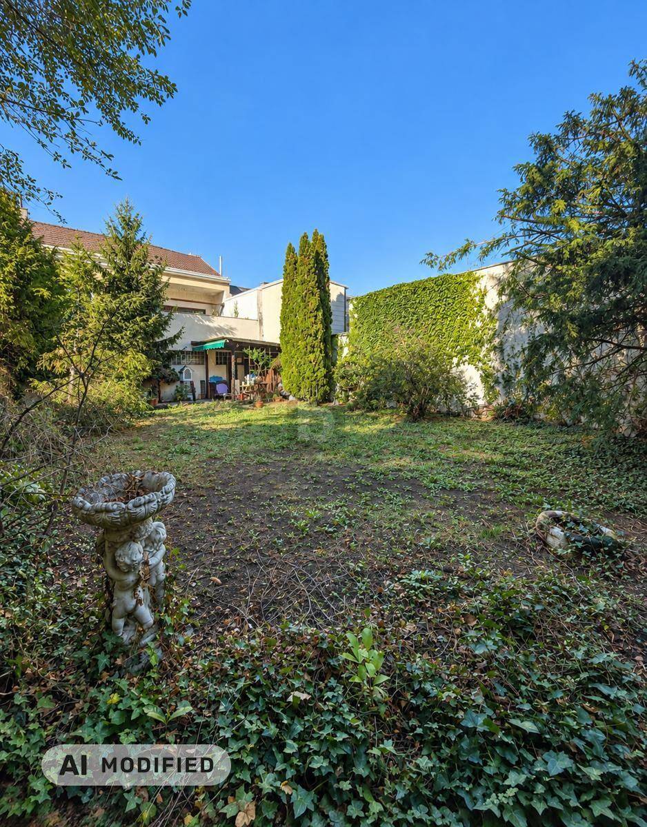 Großer, naturbelassener Garten mit altem Baumbestand, Rasenfläche und Vogeltränke.