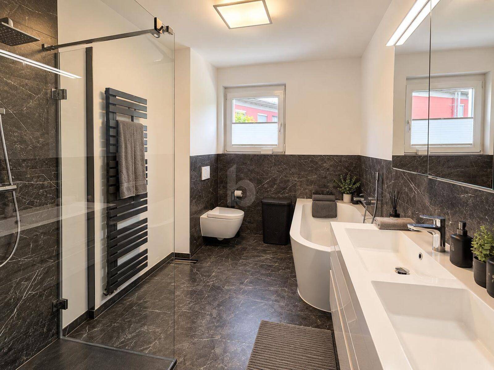 Elegantes Badezimmer mit dunklen Marmorfliesen, begehbarer Dusche und freistehender Badewanne.