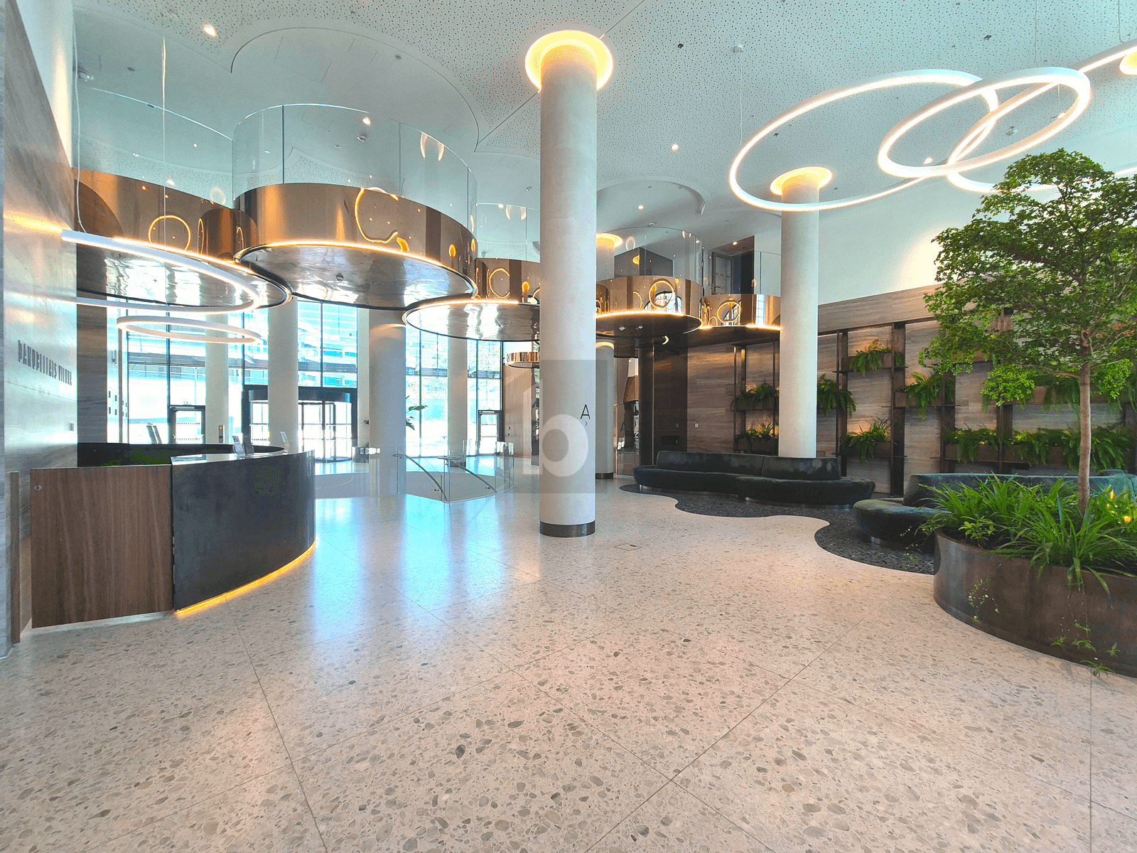 Luxuriöse Lobby mit hohen Decken, modernen Säulen und stilvoller Beleuchtung.