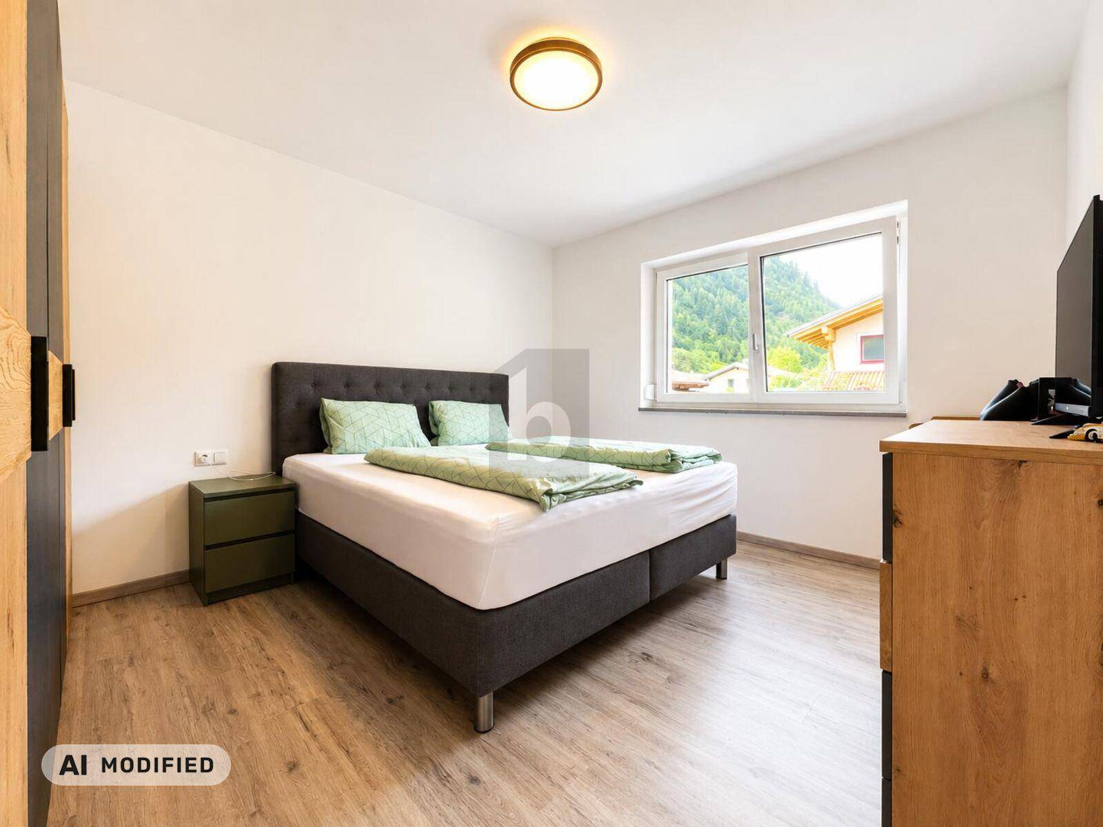 Gemütliches Schlafzimmer mit Doppelbett, Holzboden und Fenster mit Blick ins Grüne.