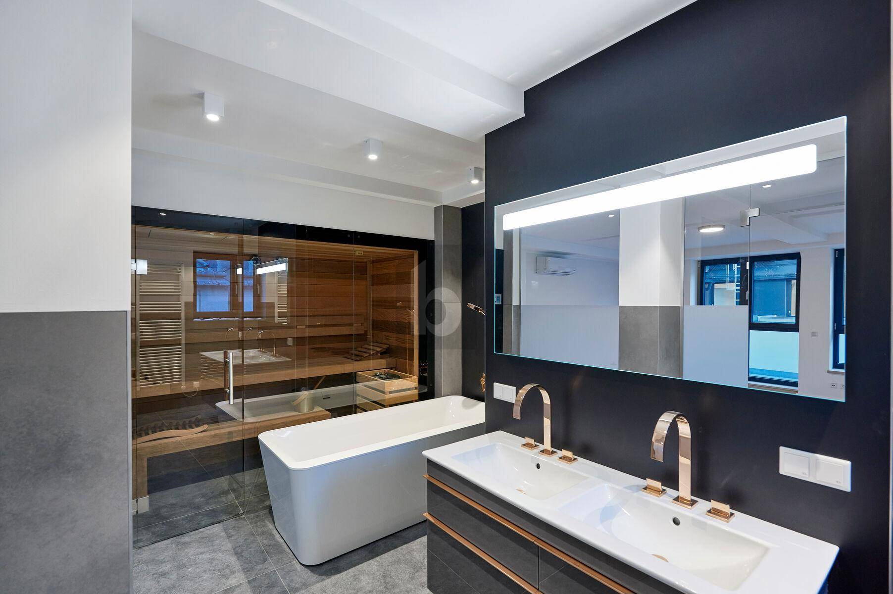 Modernes Badezimmer mit integrierter Sauna, freistehender Badewanne und Doppelwaschbecken.
