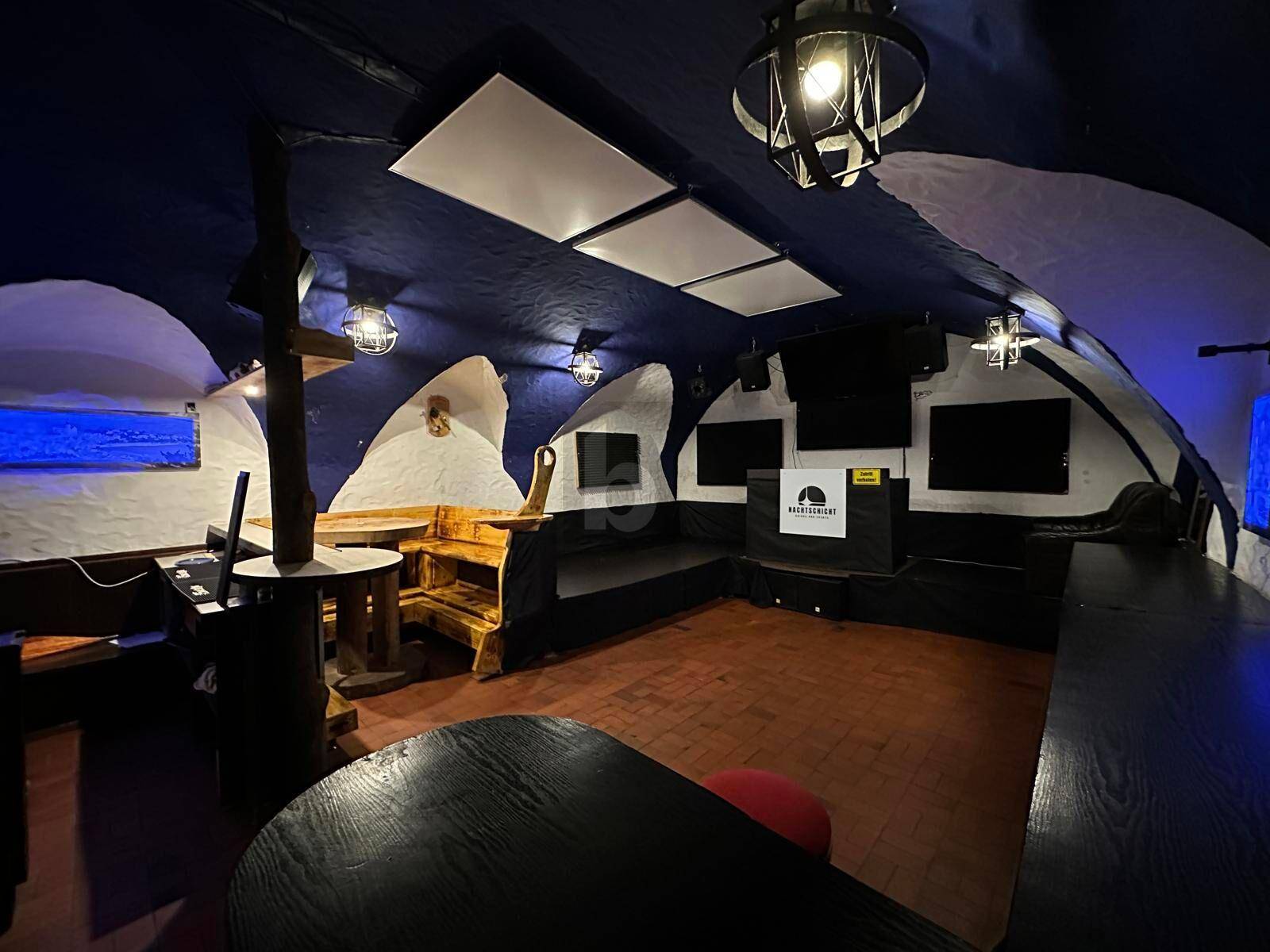 Innenansicht einer Bar mit Sitzgelegenheiten, Tischen und der charakteristischen gewölbten Decke.