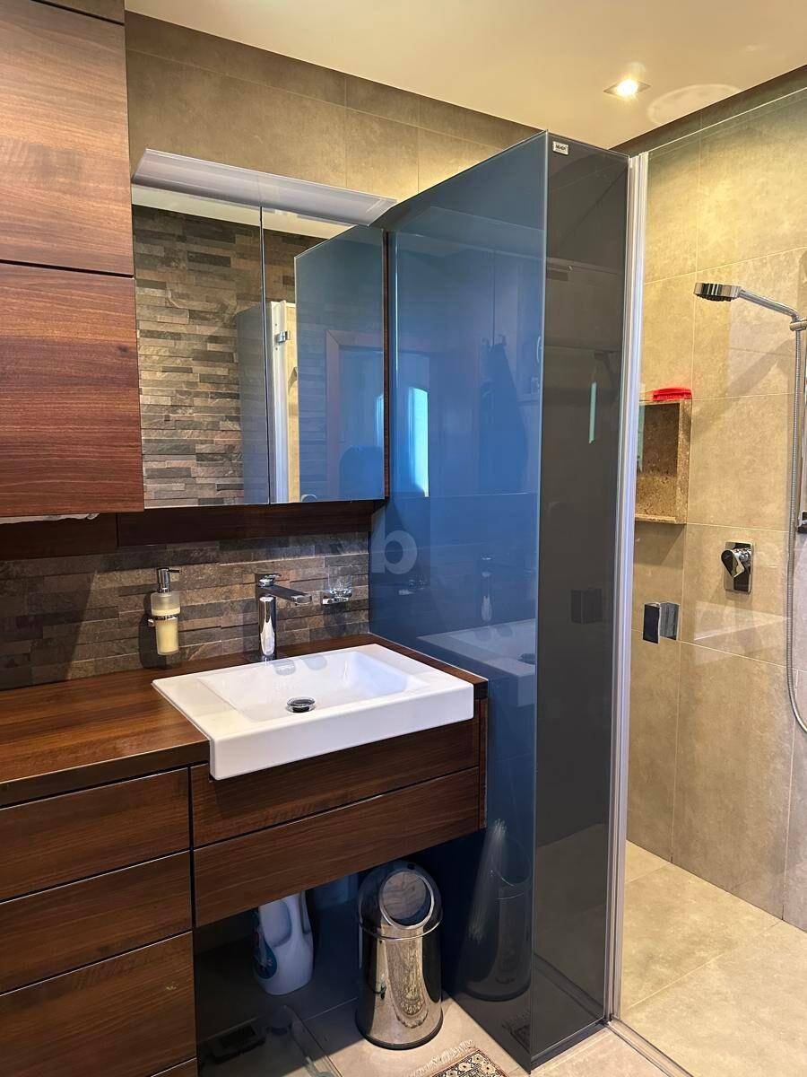 Modernes Badezimmer mit Holzwaschtisch, Einzelwaschbecken und begehbarer Dusche.