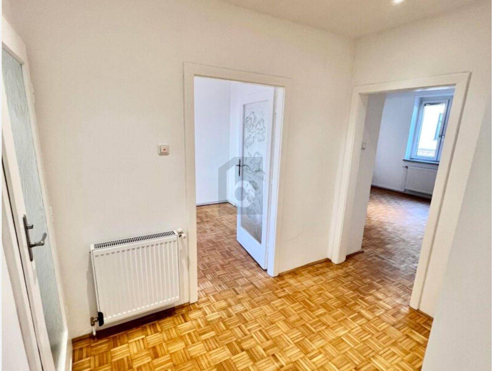 Heller Flur mit Parkettboden und Zugang zu verschiedenen Zimmern der Wohnung.