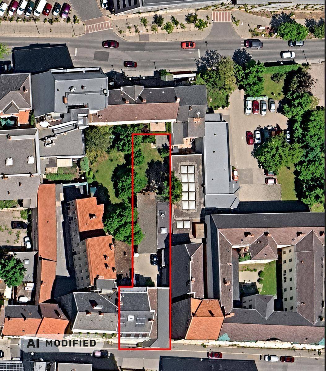 Luftaufnahme des Grundstücks mit Gartenbereich, umgeben von städtischer Bebauung.