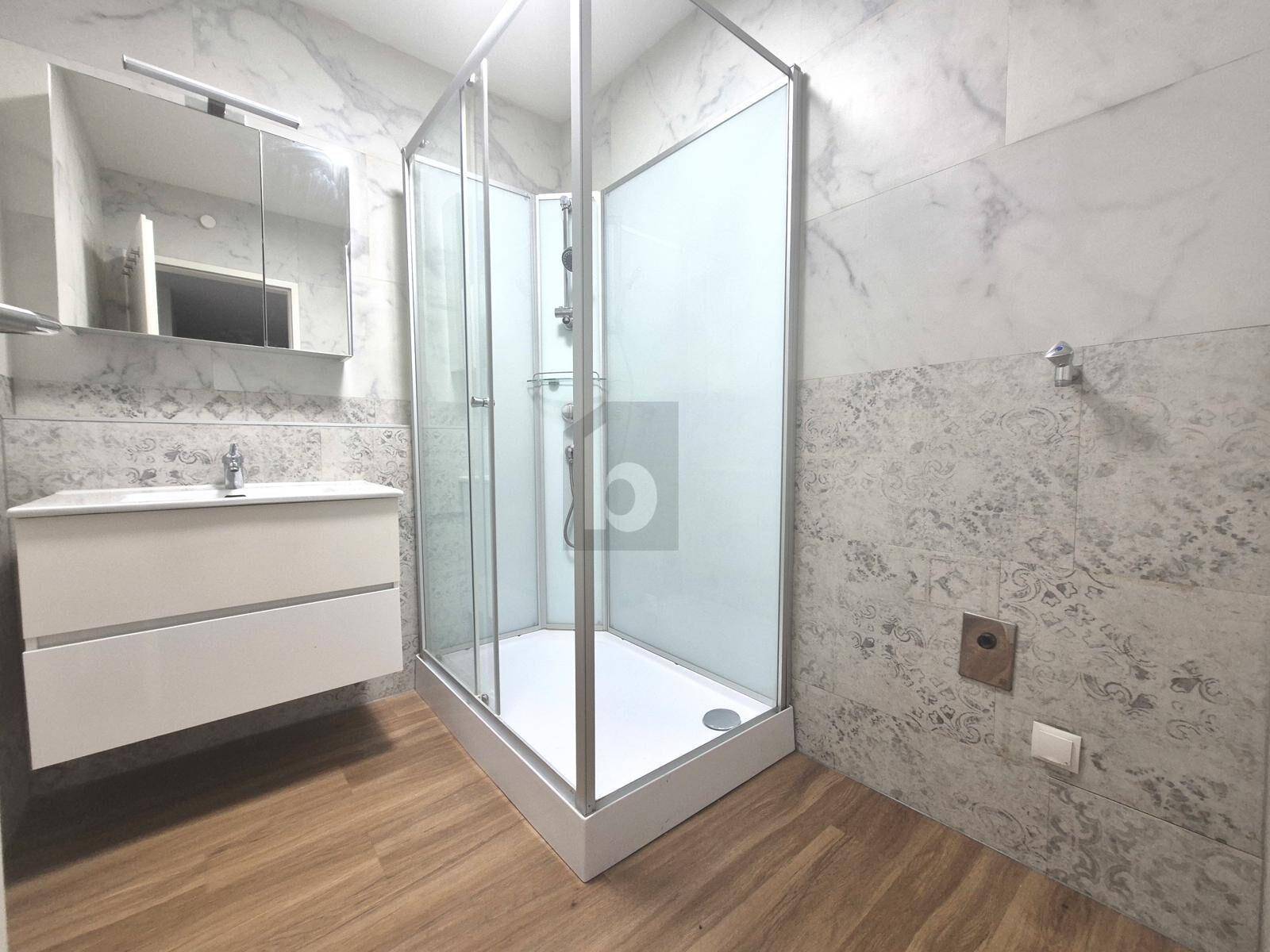 Modernes Badezimmer mit Eckdusche, Einzelwaschbecken und hellen Fliesen.