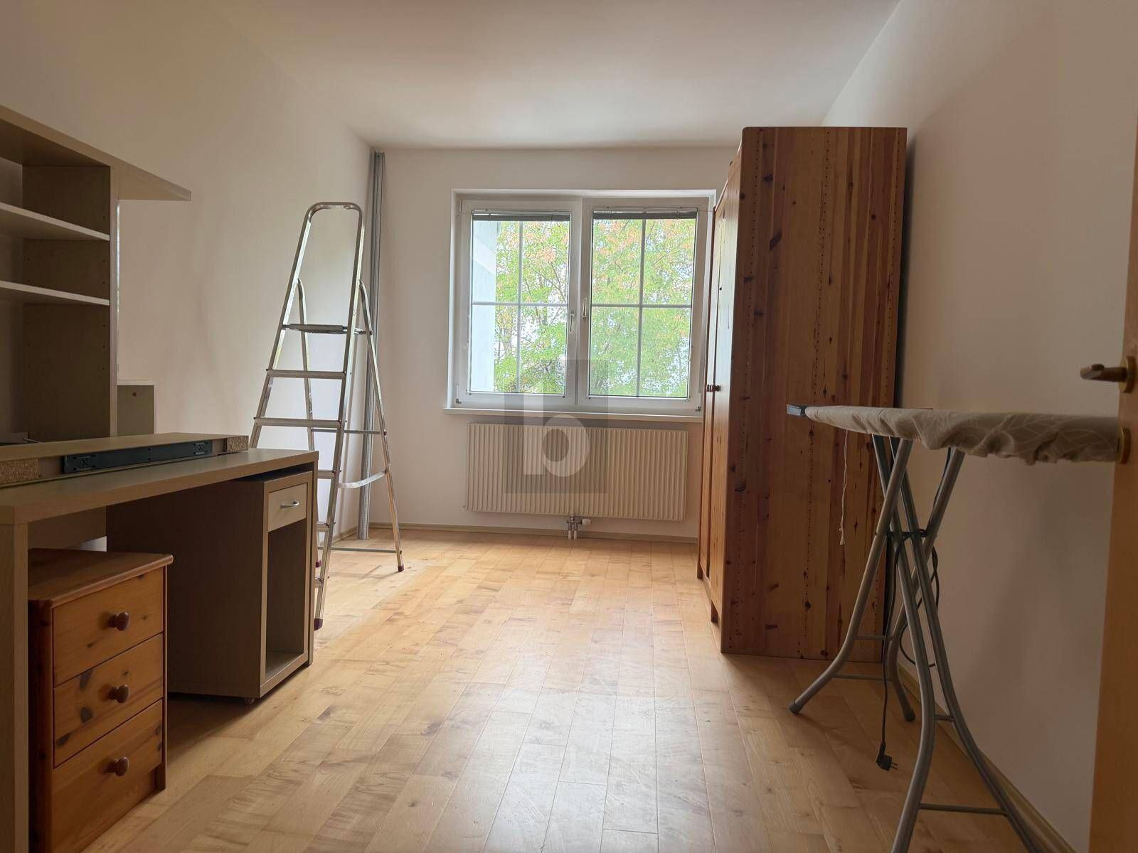 Helles Zimmer mit Holzmöbeln, Schreibtisch und Parkettboden, vielseitig als Büro oder Gästezimmer nutzbar.