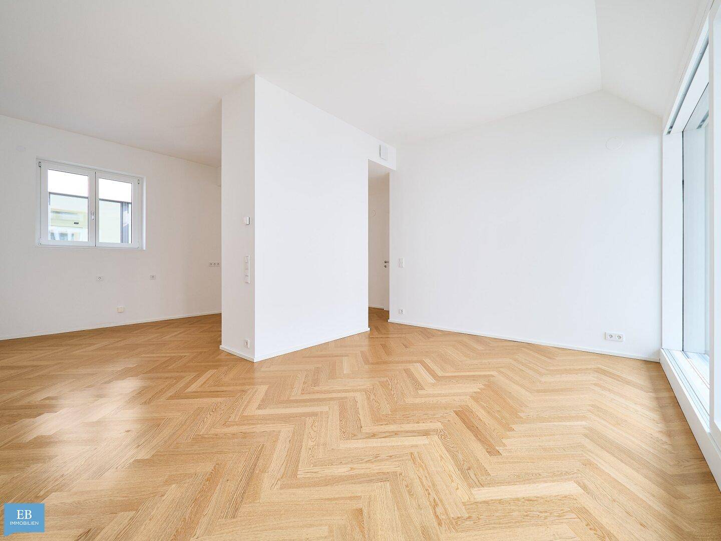 Geräumiges Zimmer mit Fischgrätparkett und weiß gestrichenen Wänden, vielseitig nutzbar.