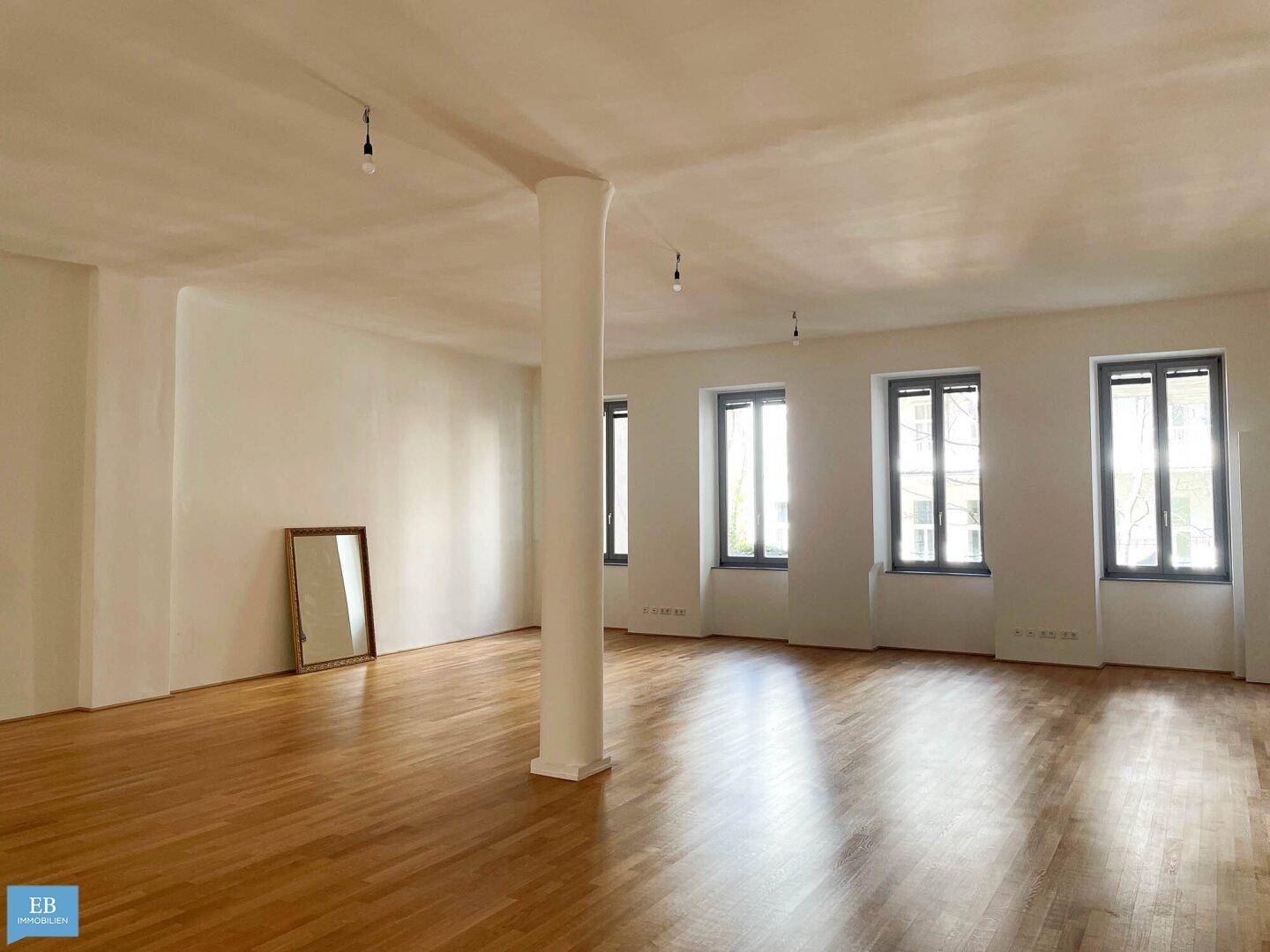 Heller und weitläufiger Wohnraum mit Parkettboden und Säule, bietet viel Gestaltungspotenzial.